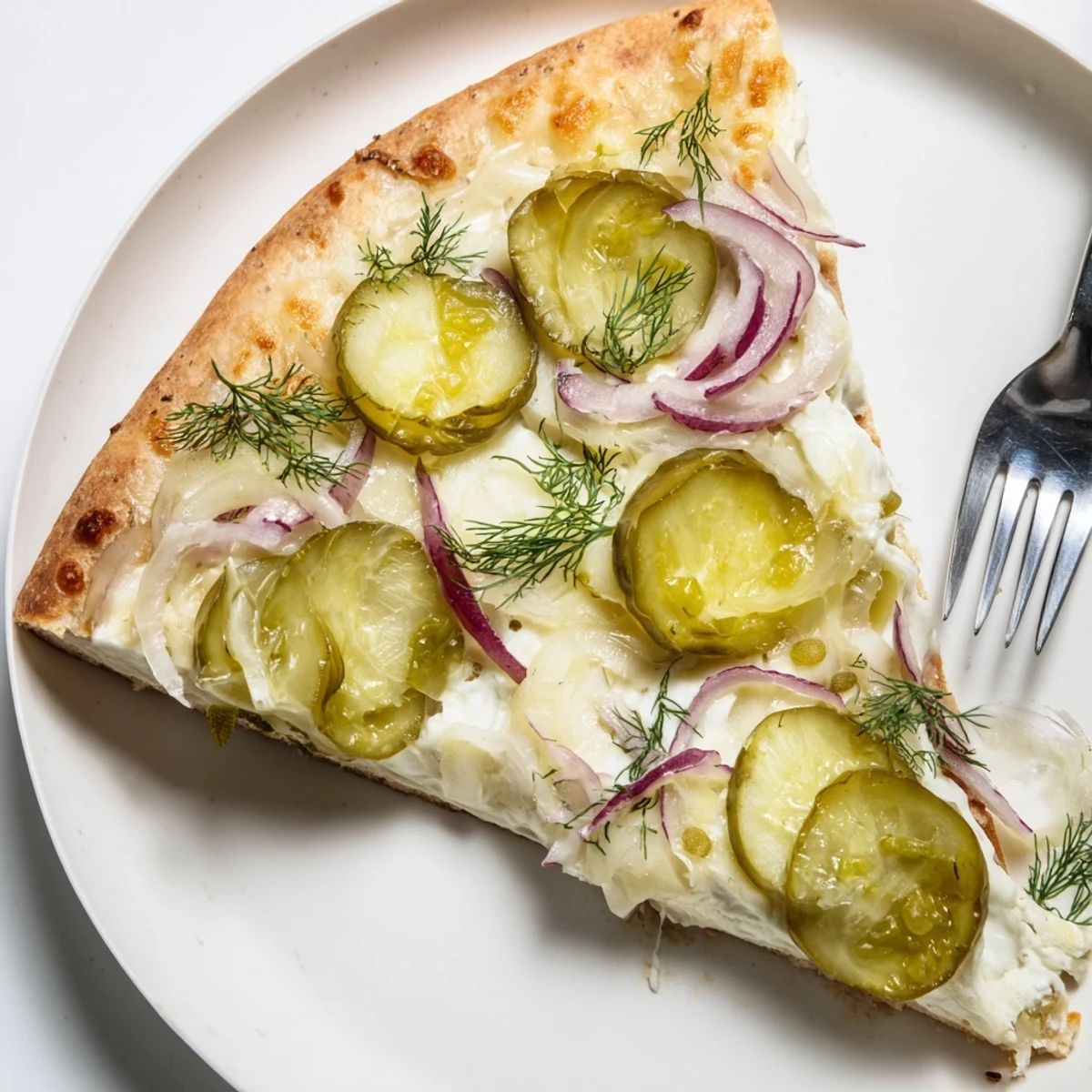 Tangy Pickle Pizza topped with creamy sauce and crunchy dill pickles, sliced and ready.  