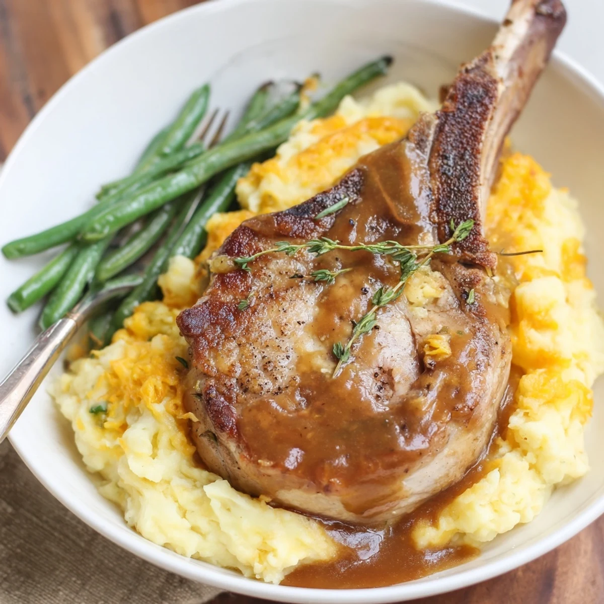 Juicy pork chops and creamy cheddar mash bowl drizzled with savory gravy.  