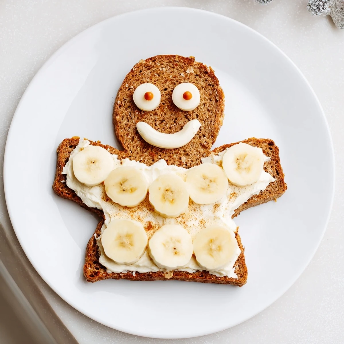 Gingerbread man sandwich cutouts with cream cheese filling, decorated with apple slices and raisins.
