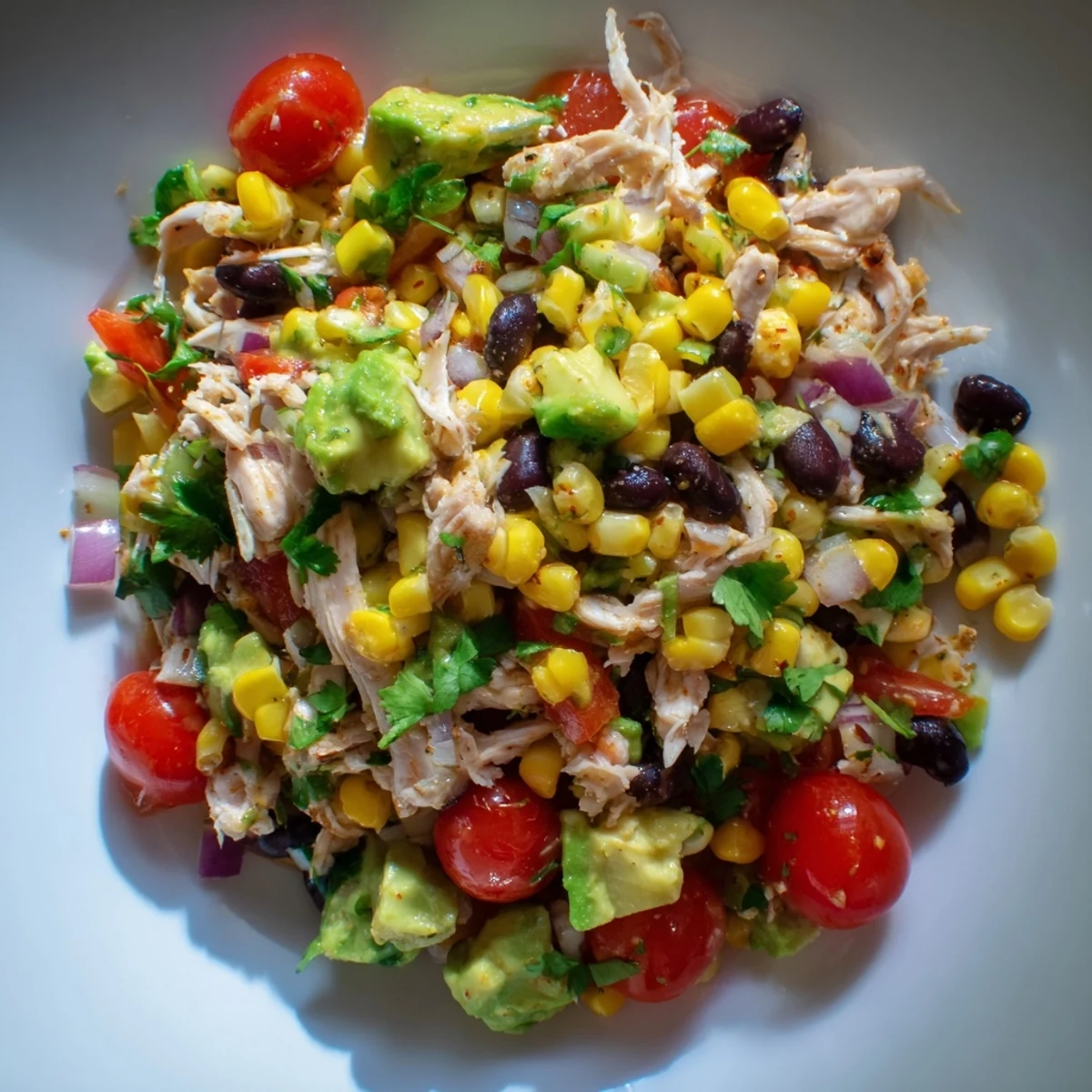 Vibrant close-up of Dense Southwestern Bean Salad, a colorful mix with creamy avocado, and fresh cilantro.