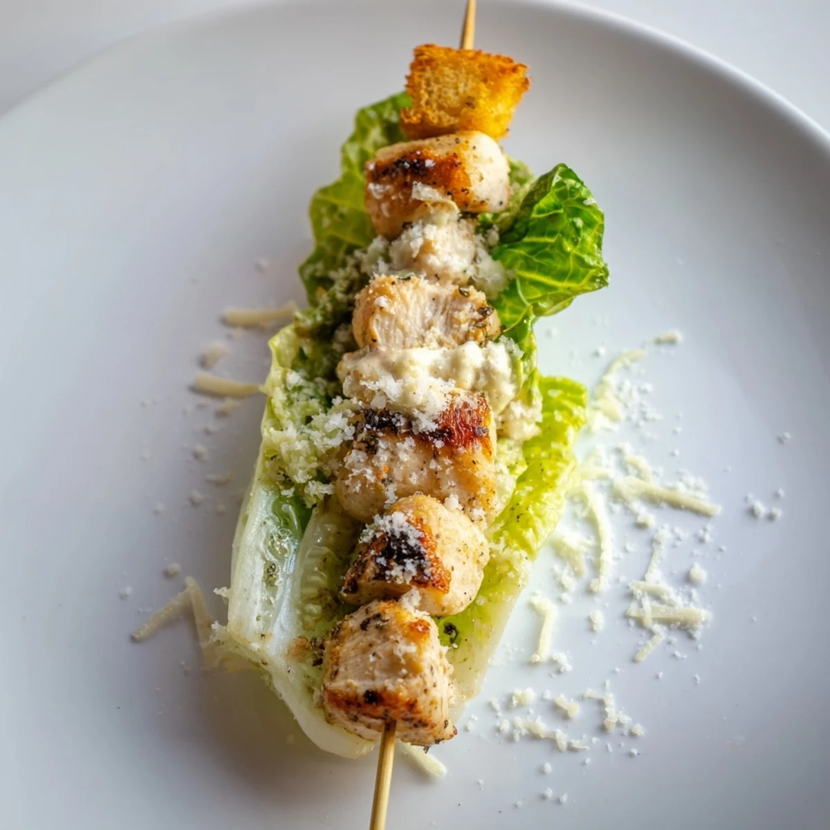 Chicken Caesar Salad Skewers arranged on a platter, showcasing grilled chicken, lettuce, croutons, and Caesar dressing.