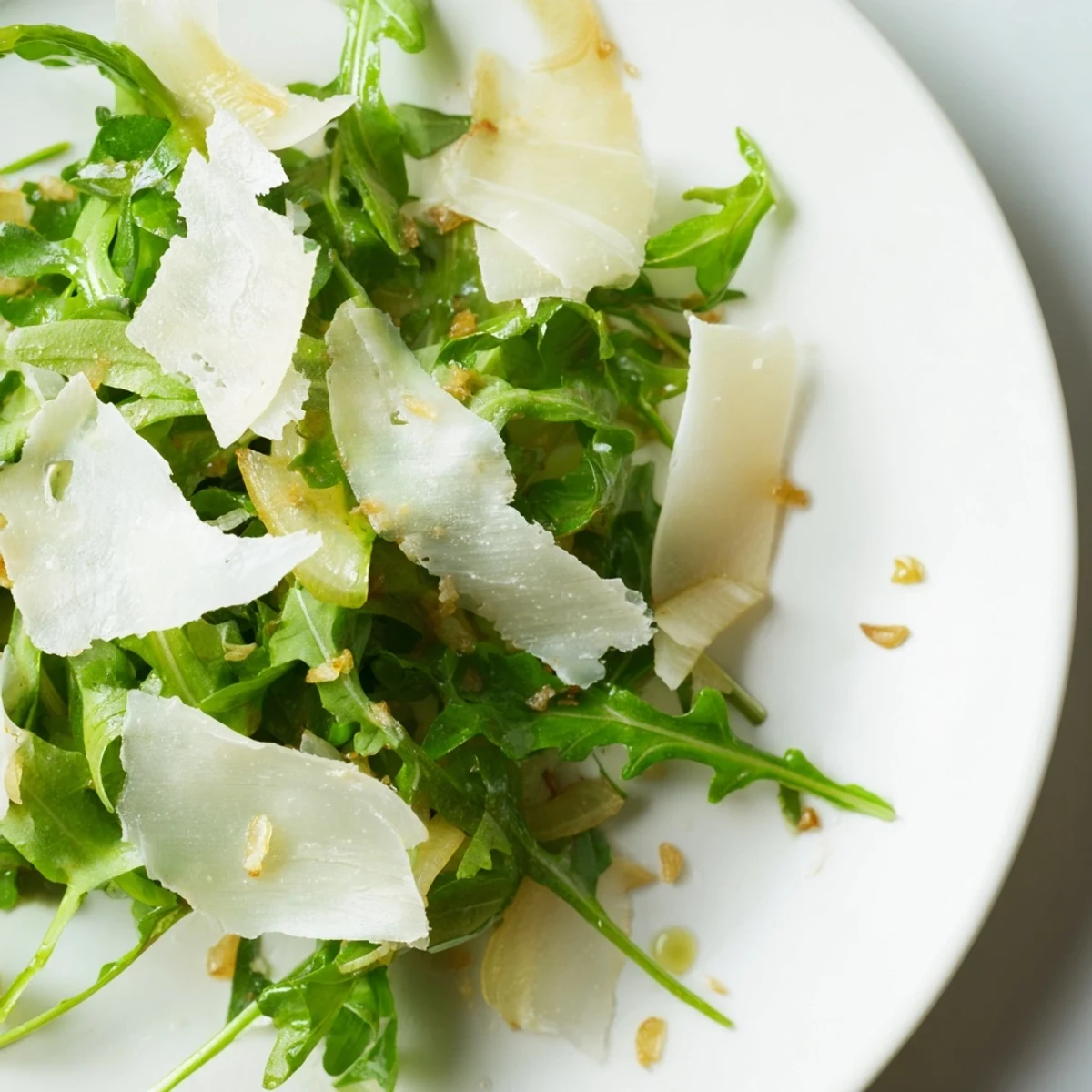 Fresh arugula salad with a bright lemon dressing, scattered with Parmesan shavings, ready to enjoy.