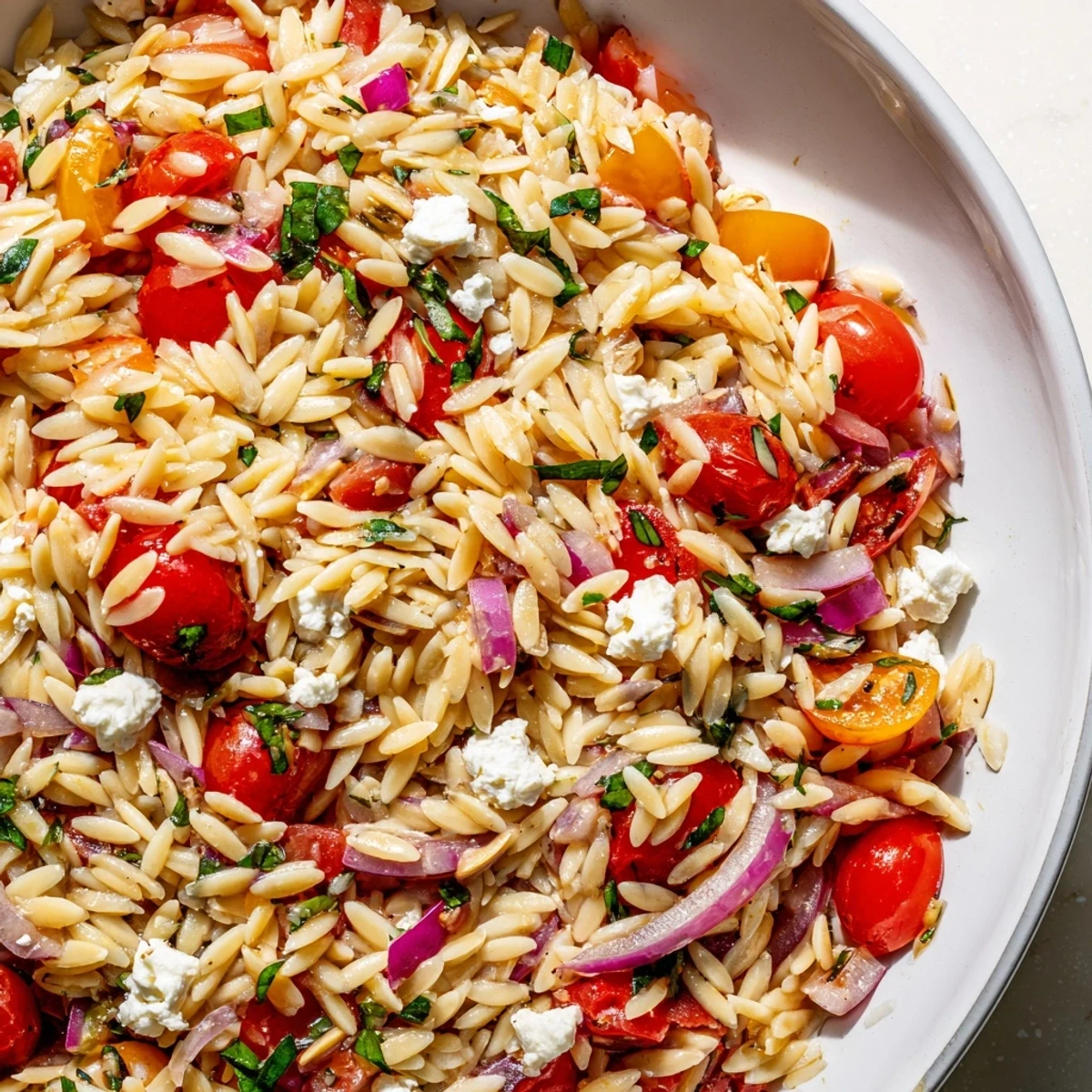 Vibrant Tomato Feta Orzo pasta salad with juicy tomatoes and creamy feta, ready to enjoy.