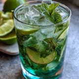 Cool and crisp alcohol-free mojito bursting with muddled lime, mint, and cucumber, topped with sparkling water and garnished with fresh herbs.