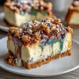 Creamy cheesecake bars featuring festive Mardi Gras colors swirled atop a buttery cinnamon base, ideal for sharing at parties.