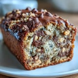 Rich banana bread with swirls of creamy peanut butter and chunks of peanut butter cups, baked to golden perfection and studded with chocolate chips.