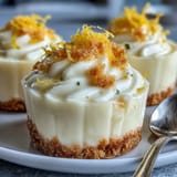 Individual lemon mousse cups with buttery shortbread cookies, garnished with mint and lemon zest curls.  