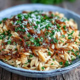 Golden caramelized onion orzo recipe, a comforting vegetarian main with herbs.