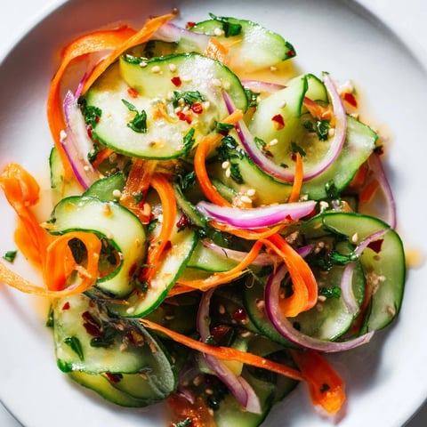 A vibrant cucumber salad remix drizzled with sesame oil and fresh herbs.  