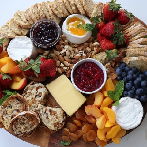 Colorful jam-infused brunch board featuring fresh fruits, cheeses, and artisan breads.  