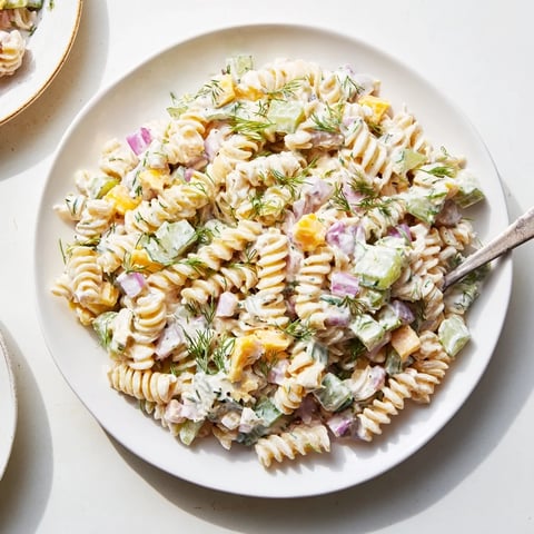 Creamy dill pickle pasta salad loaded with cheddar cheese, ready for your next picnic.