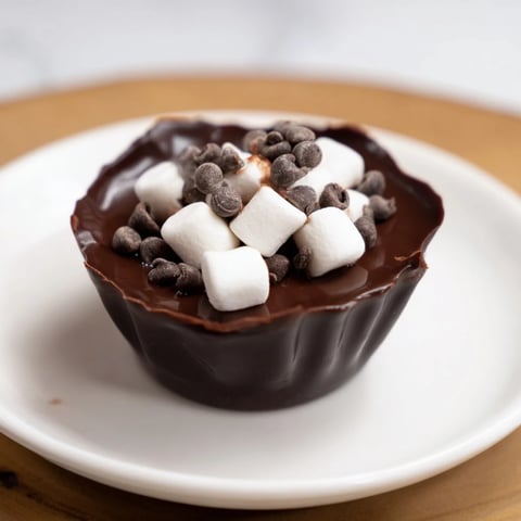 Image of a rich, warm Budget-Friendly Hot Cocoa Bomb Cup, with melted chocolate and marshmallows floating.