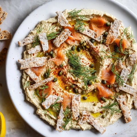 Delectable "Driftwood Beach" appetizer, featuring smoked fish and driftwood crackers on creamy hummus.