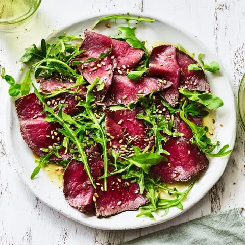 Delicate Origami Fold Beef Appetizer, arranged artfully on a bed of arugula, ready to be enjoyed.