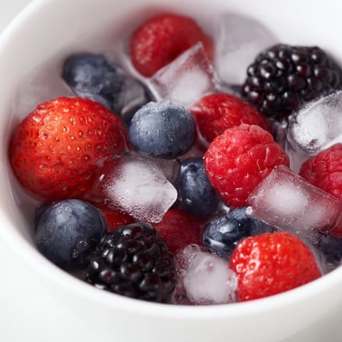 A beautiful Nature's Cereal Bowl, bursting with colorful fresh berries in chilled coconut water.