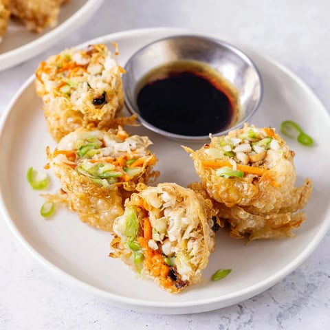 Golden-brown Crispy Rice Paper Dumplings, sizzling in a pan, ready for dipping sauce.