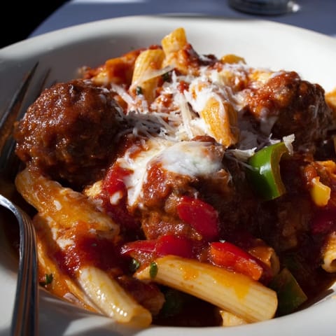 Hearty Italian Meatball Pasta Skillet topped with melted cheese and fresh basil.  