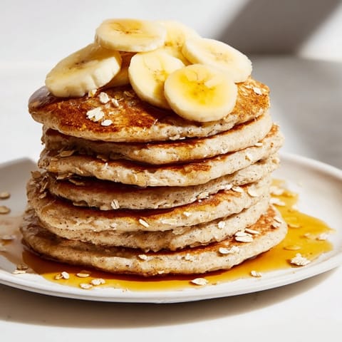 Fluffy banana oat pancakes, visually appealing with cooked oat edges, perfect for a cozy morning.