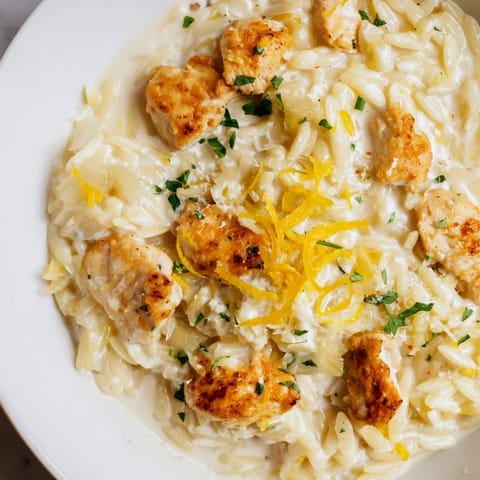 Golden chicken bites nestled with creamy orzo in Creamy Lemon Chicken Orzo, ready to enjoy tonight.