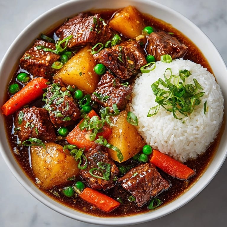 Enjoy hearty Slow Cooker Japanese Curry Beef Stew with fluffy rice, garnished with green onions.