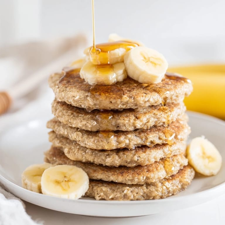 A beautiful plate of banana oat pancakes, topped with fresh berries, ready for a delicious brunch.