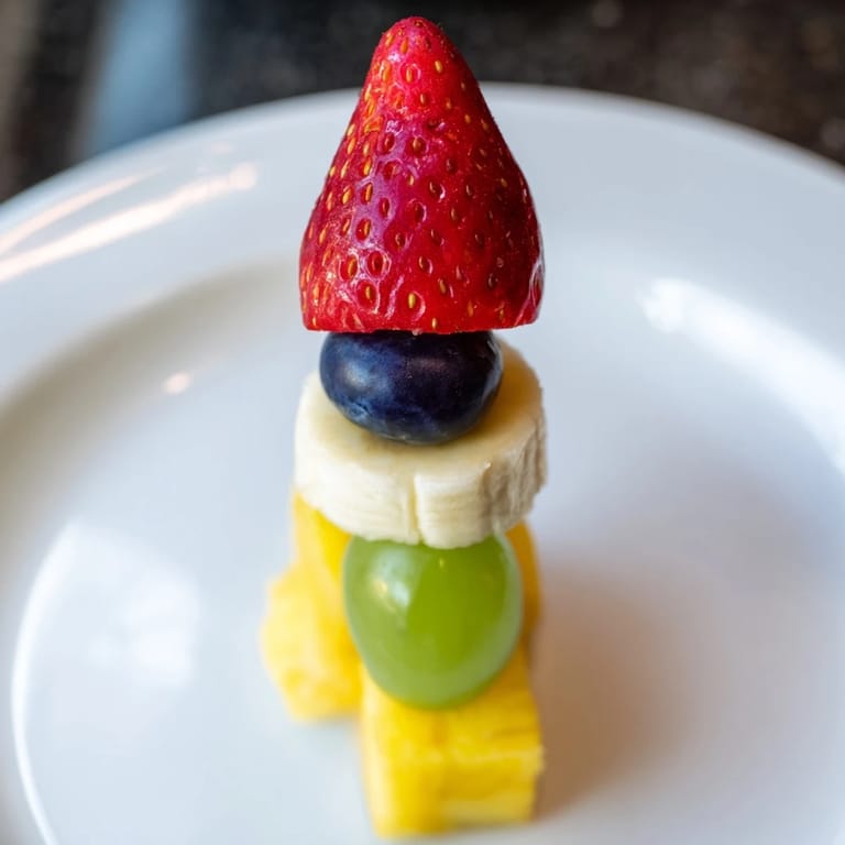 Imagine the fun: sweet rocket ship fruit skewers with pineapple flames, perfect for kids.