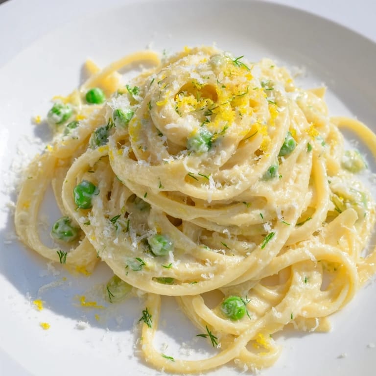 A heaping serving of creamy, vibrant Creamy Dill Pasta, enriched with Parmesan and fresh dill atop a white plate.