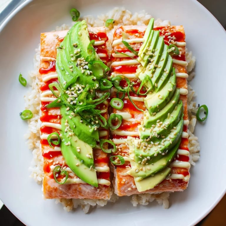 A beautiful, close-up view of the Emily Mariko Salmon Rice Bowl, with fluffy rice and spicy mayo.
