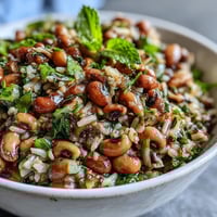 Fresh Southern Black Eyed Pea Salad with crisp celery and red onion in a zesty lemon-mint vinaigrette, served chilled in a white bowl.